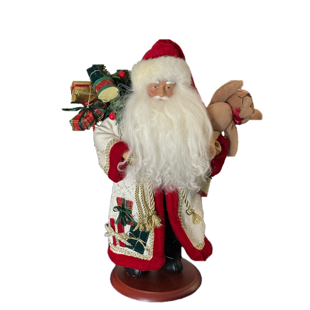 White robed Santa has a teddy bear and a pack full of toys.